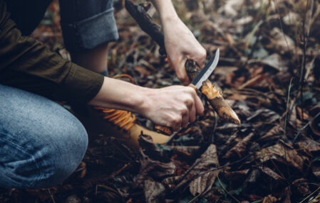 mujer cortando un tronco